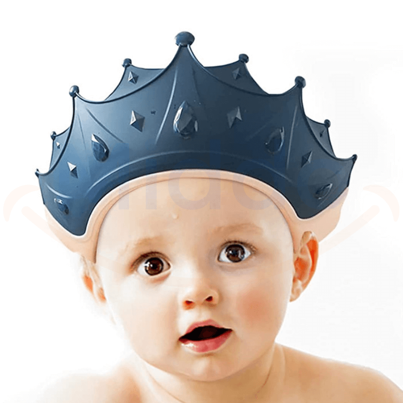 bébé portant un bonnet de douche en forme de couronne bleu marine pendant le bain