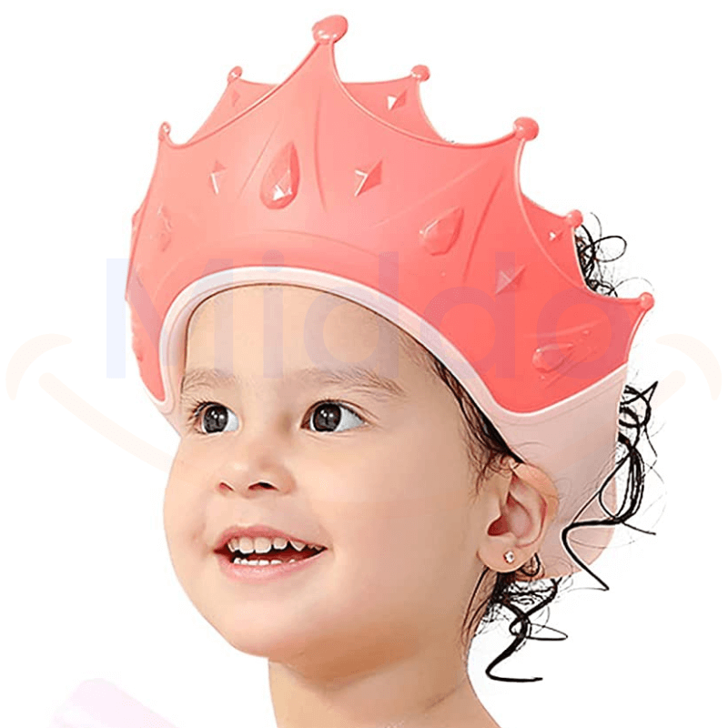 enfant portant un bonnet de douche en forme de couronne rose pendant le bain