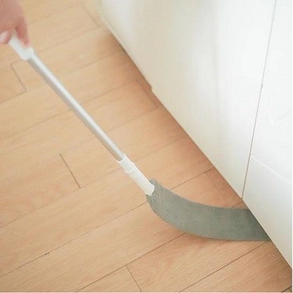 chiffon extensible utilisé sous le réfrigérateur pour nettoyer les endroits inaccessibles