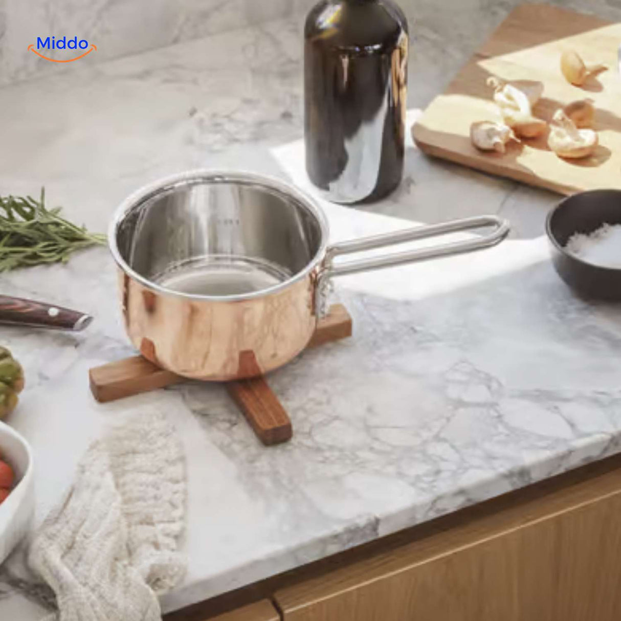 dessous de verre en bois avec une casserole en cuivre sur un plan de travail de cuisine