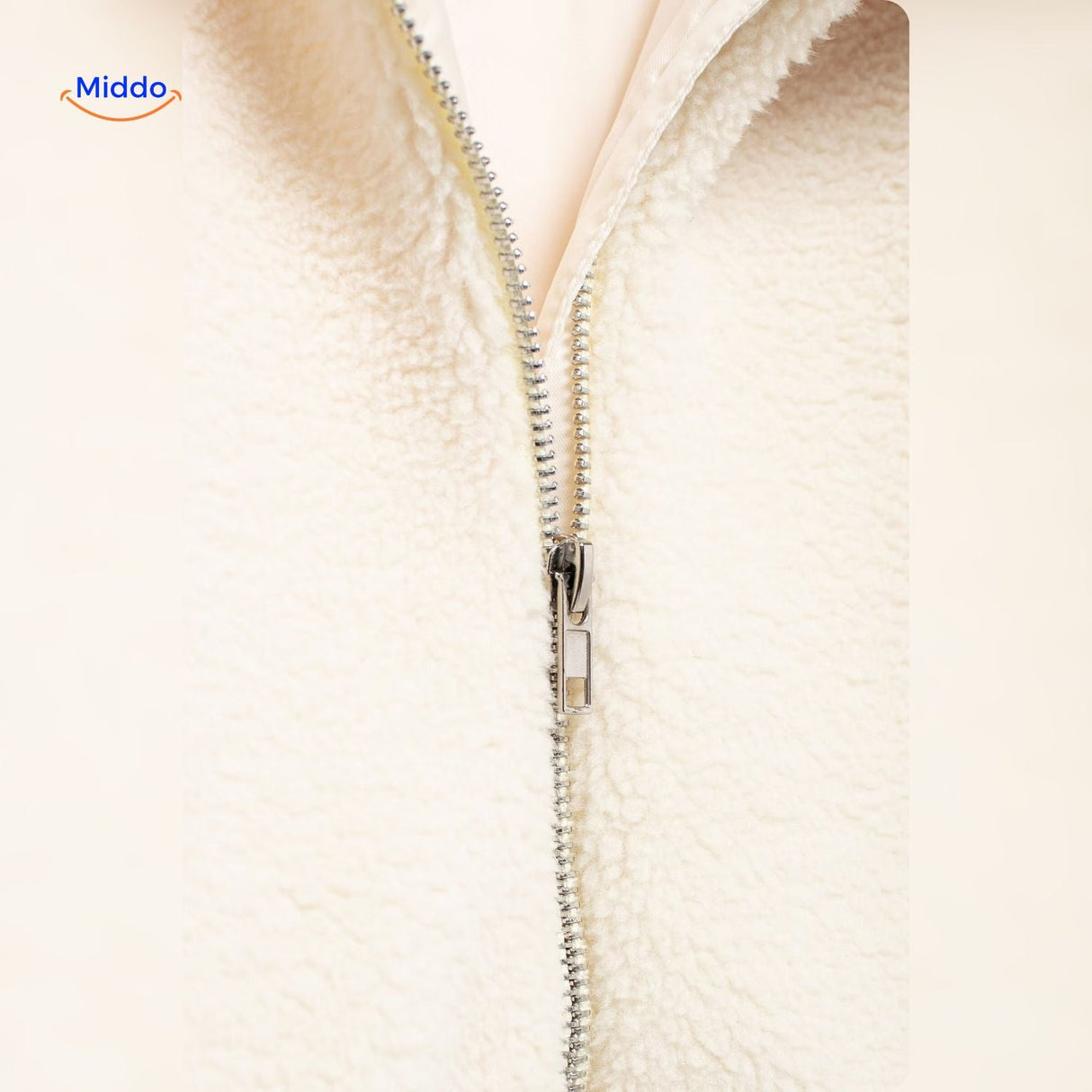 manteau en laine teddy blanc porté dans un ascenseur, look urbain et confortable