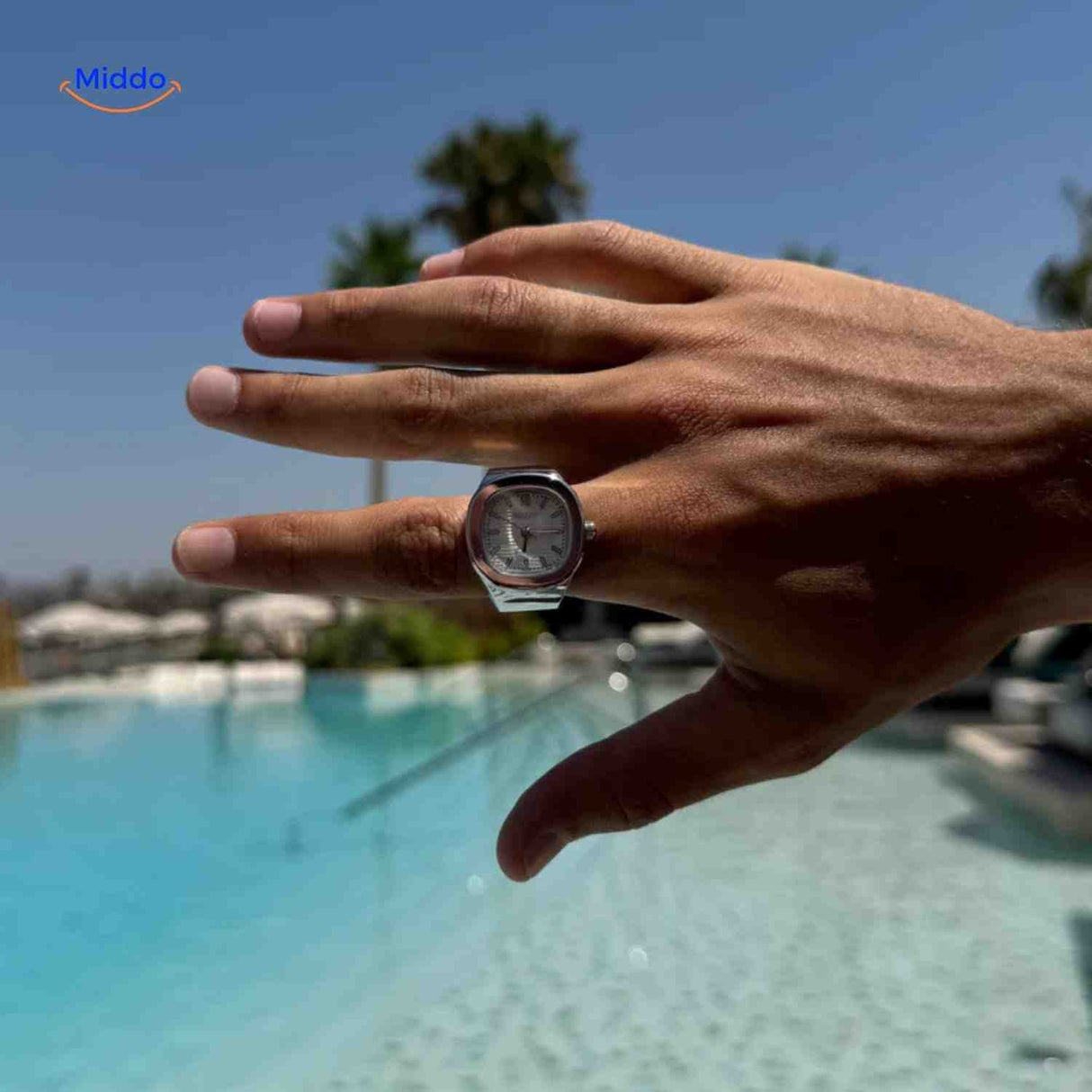 montre-bague argent cadran blanc portée sur une main, vue en situation