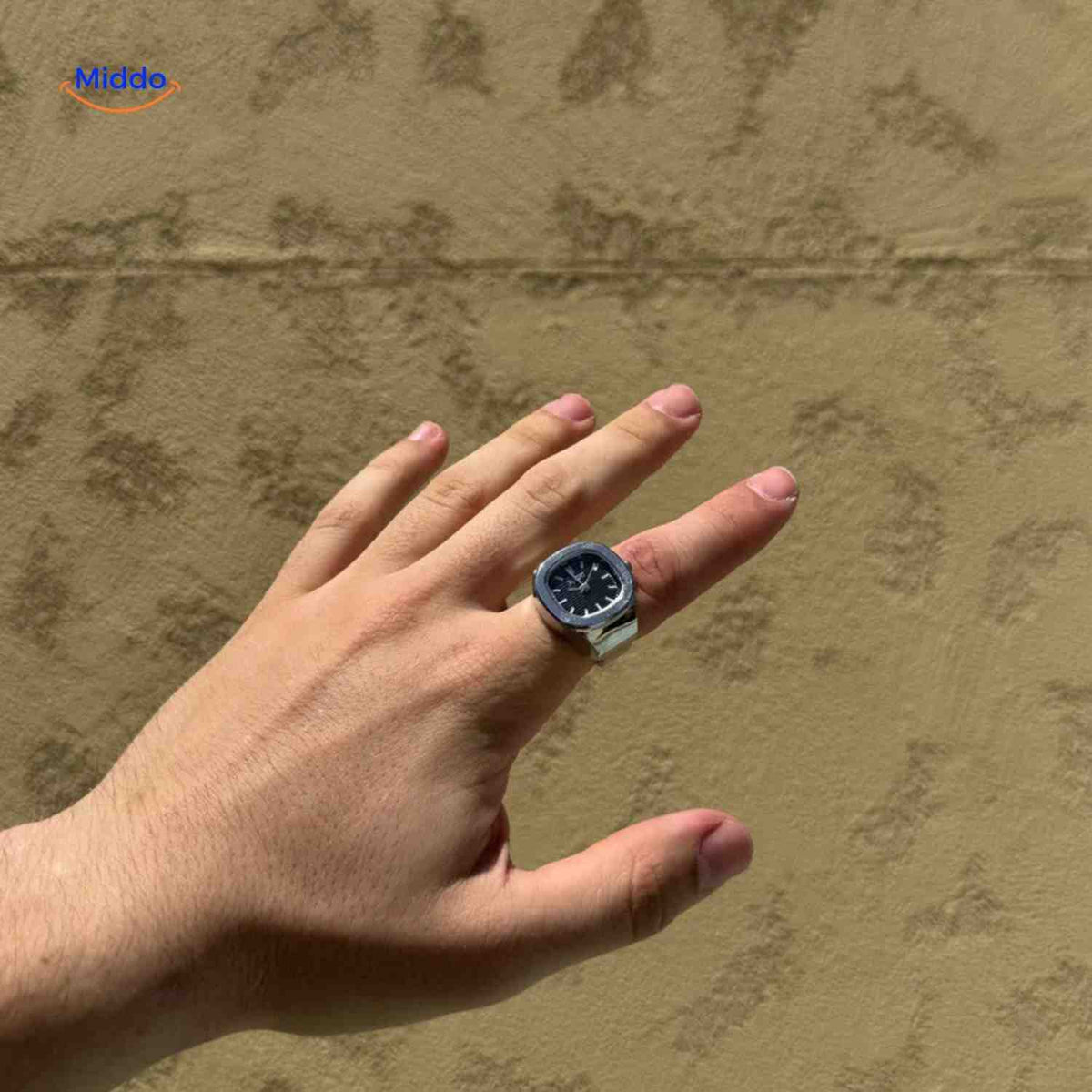 montre-bague argent avec cadran noir portée sur une main, accessoire élégant