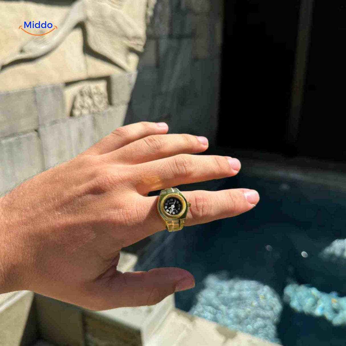 montre-bague dorée quartz portée par un homme, vue de la main