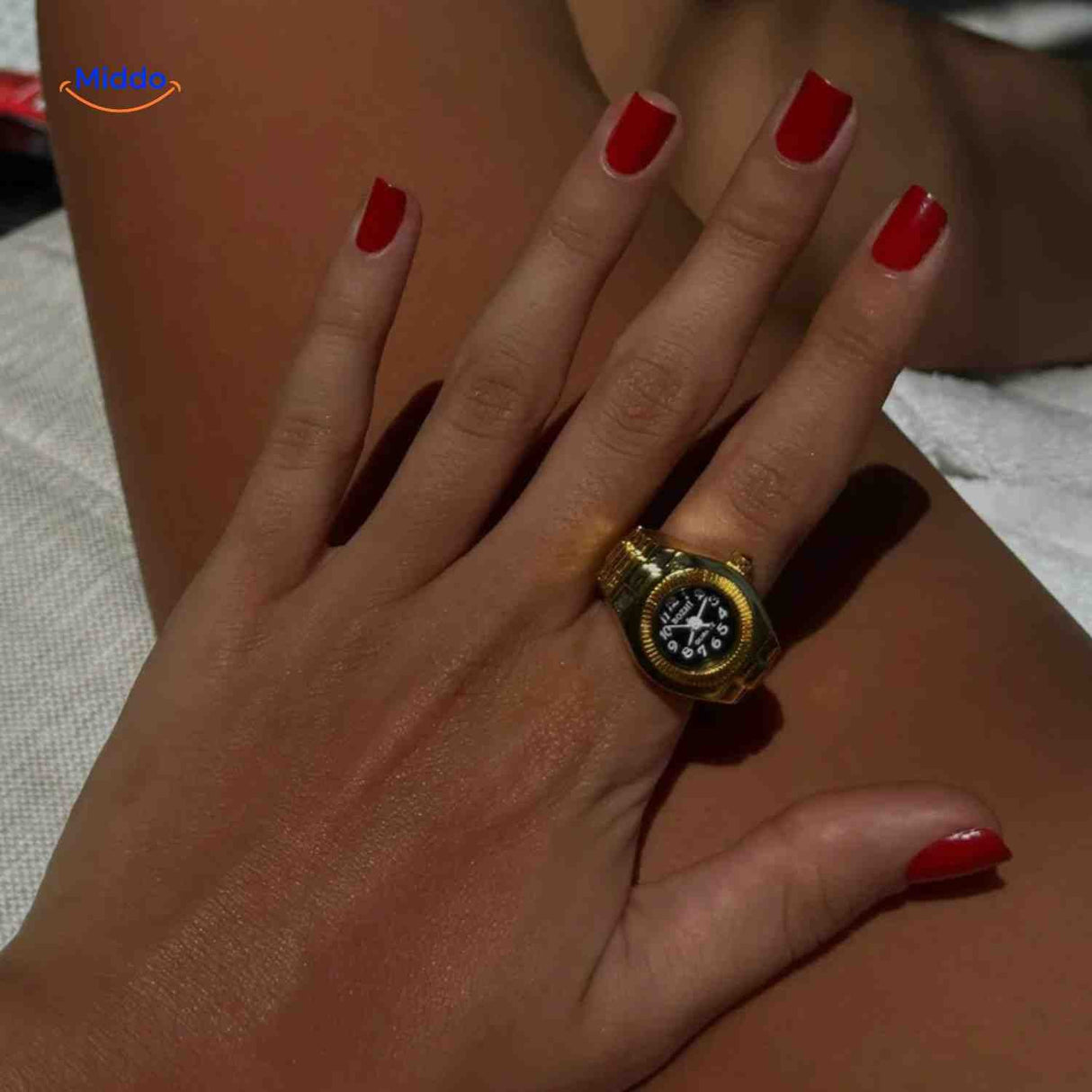 montre-bague dorée mise en valeur sur une main féminine soignée