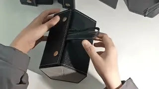 mains qui déplient l'étui à lunettes noir 6 compartiments pour montrer la fonction d'ouverture