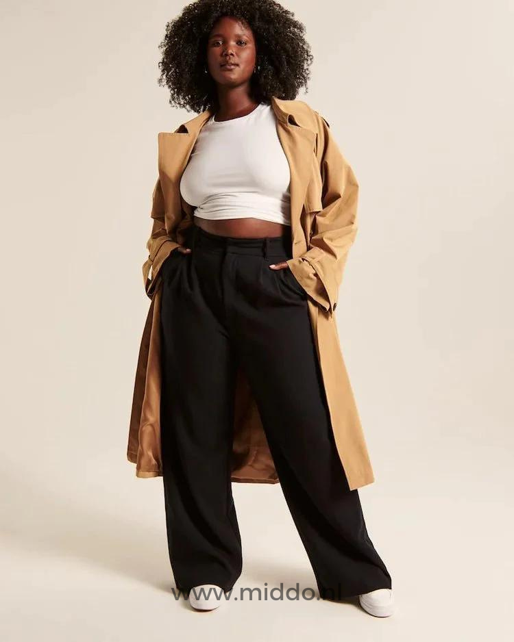 pantalon large femme noir vue de face, porté sous une longue veste beige avec baskets blanches