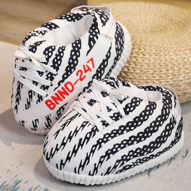 pantoufles sneakers à rayures noir et blanc avec lacets blancs, sur surface en osier