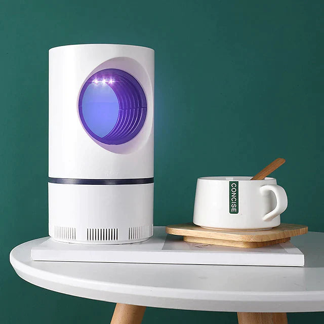 piège à moustiques posé sur une table à côté d'une tasse de café, ambiance maison