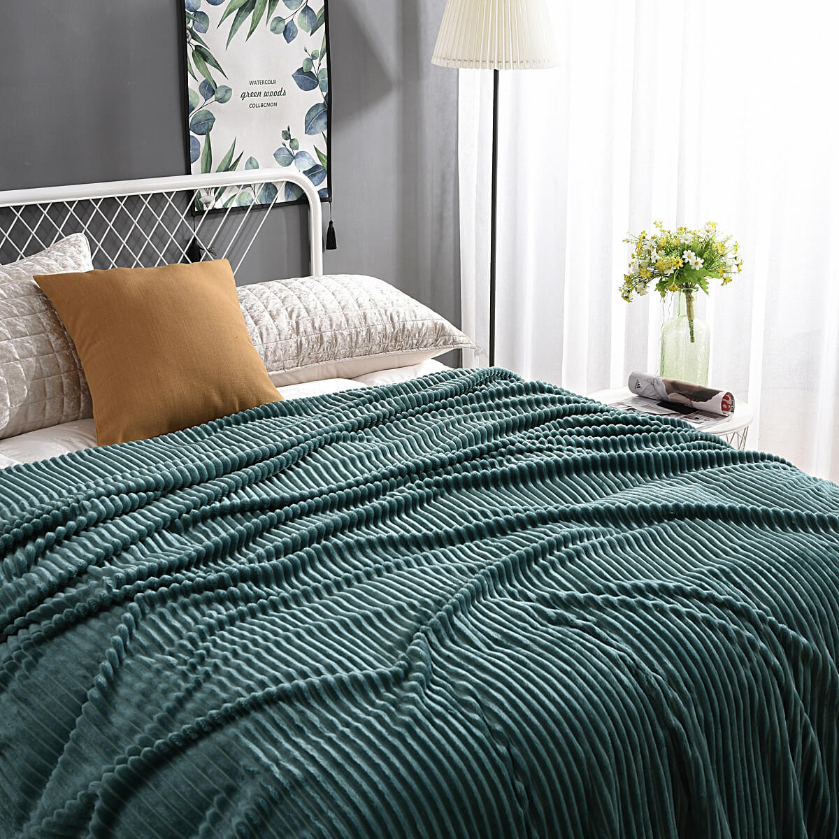 plaid en velours polaire vert foncé élégamment disposé sur un lit avec coussins assortis