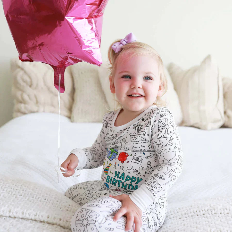 fille portant un pyjama à colorier motif anniversaire avec des ballons colorés