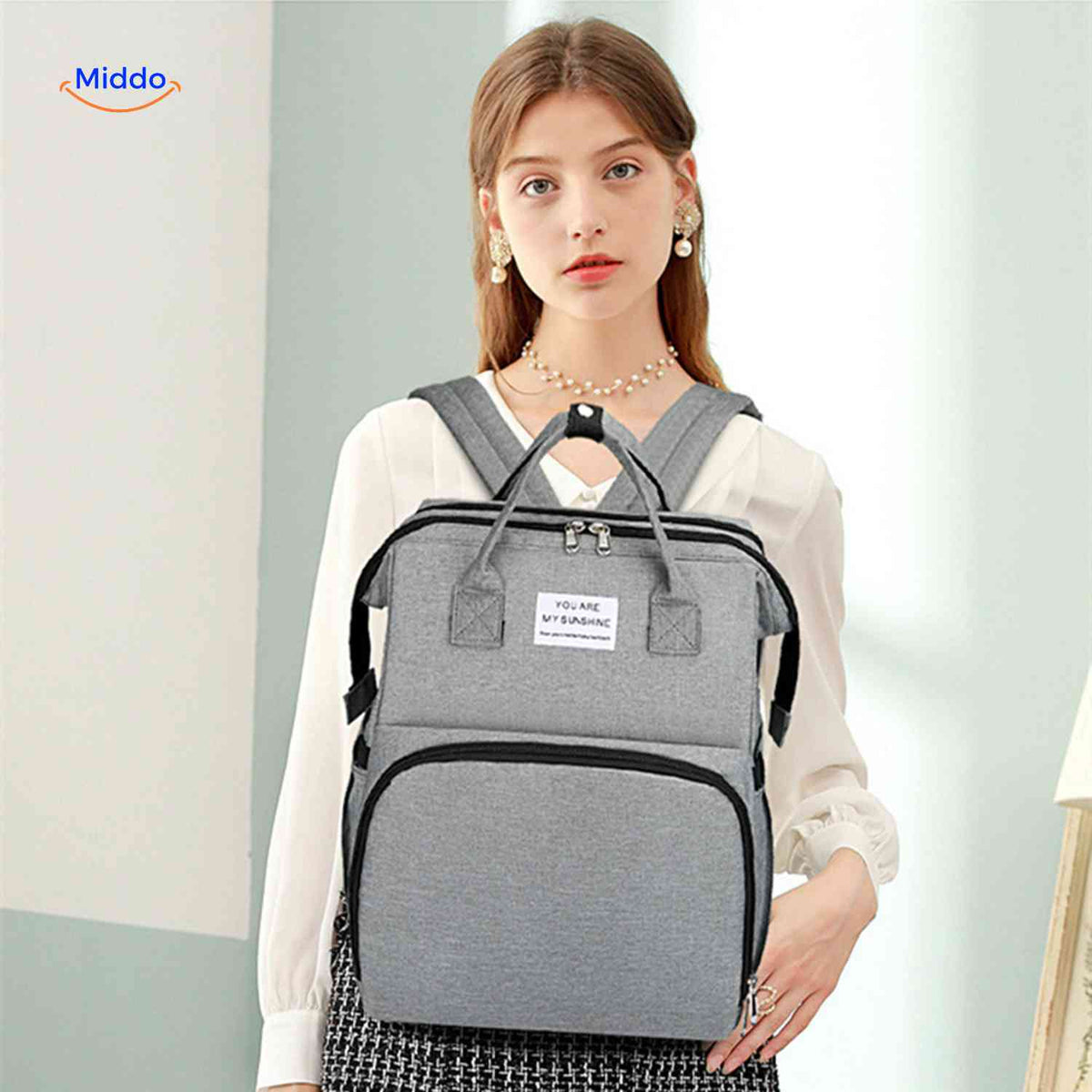 sac à dos bébé gris avec look élégant et design soigné pour les parents modernes