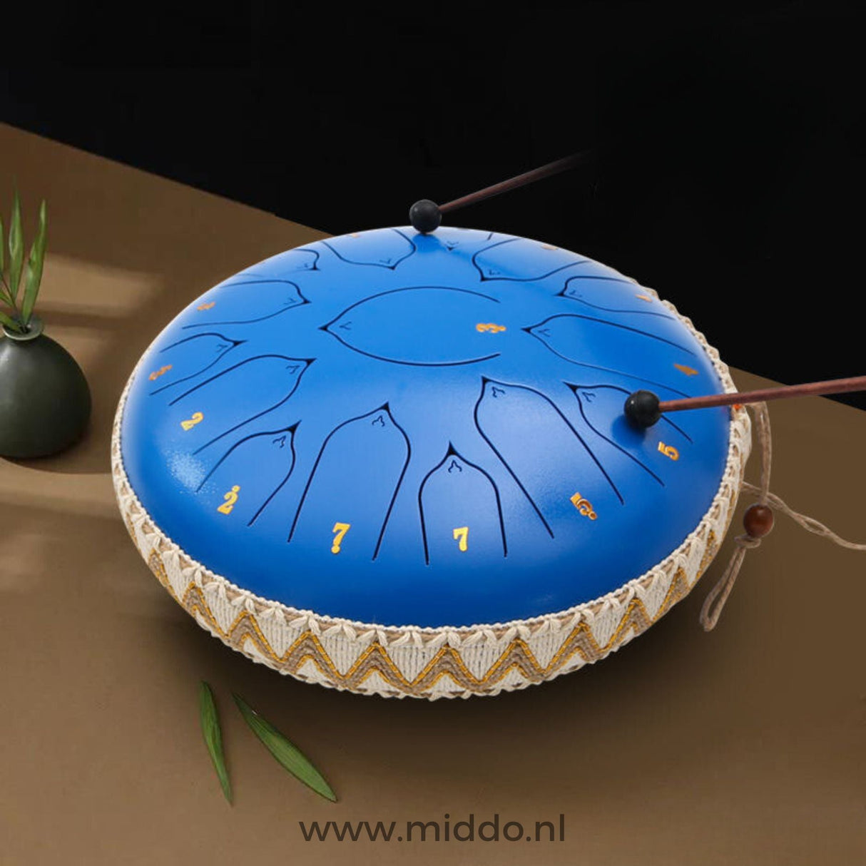 mains jouant un steel tongue drum bleu 33 cm avec des mailloches