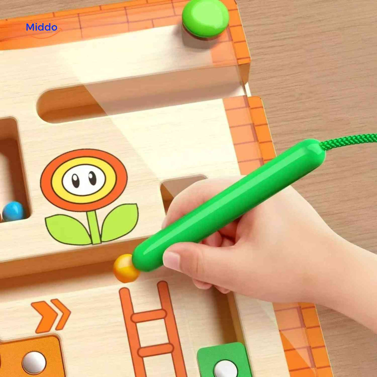 stylo magnétique guidant des billes colorées dans le labyrinthe éducatif en bois
