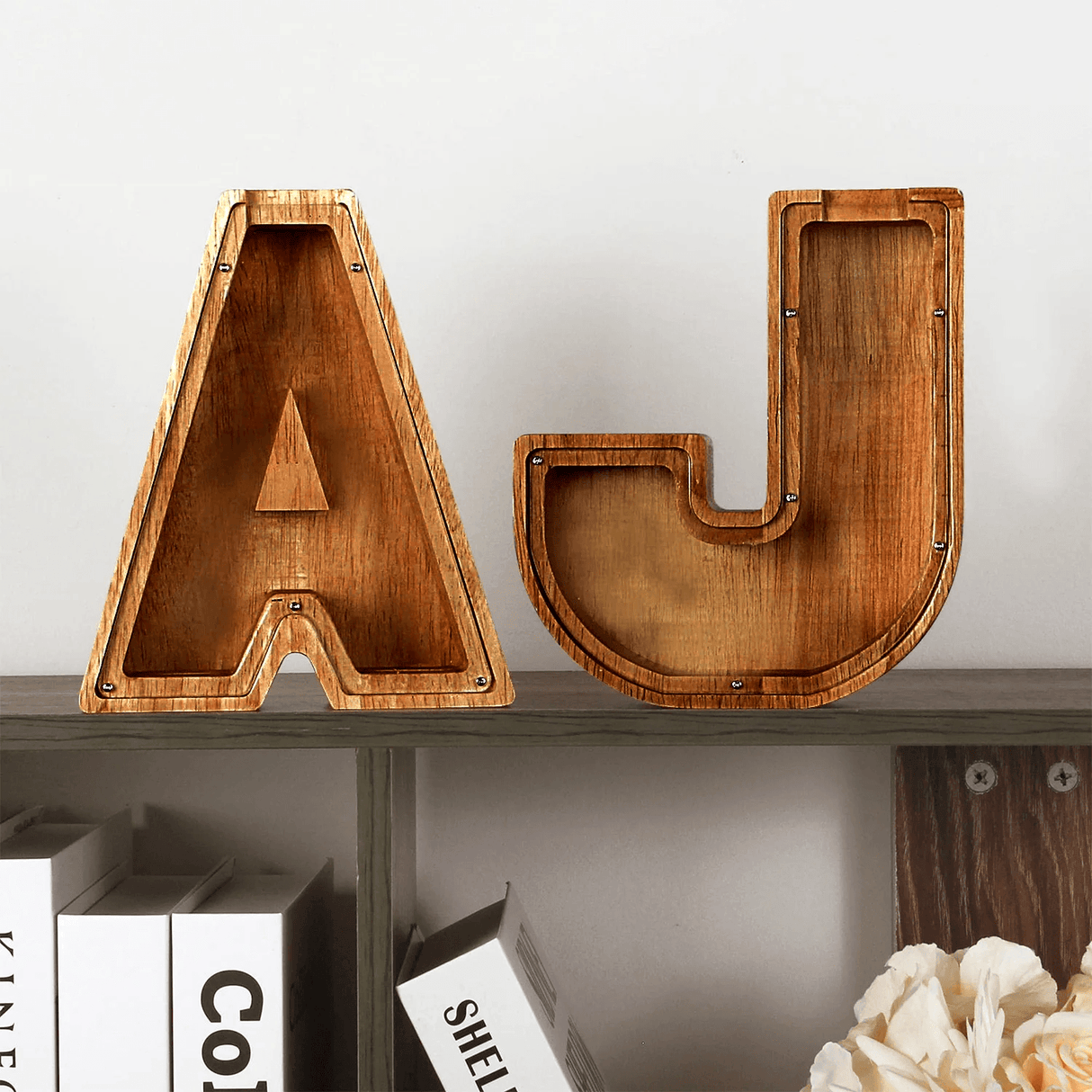 tirelires lettres A et J en bois posées sur une étagère en guise de décoration