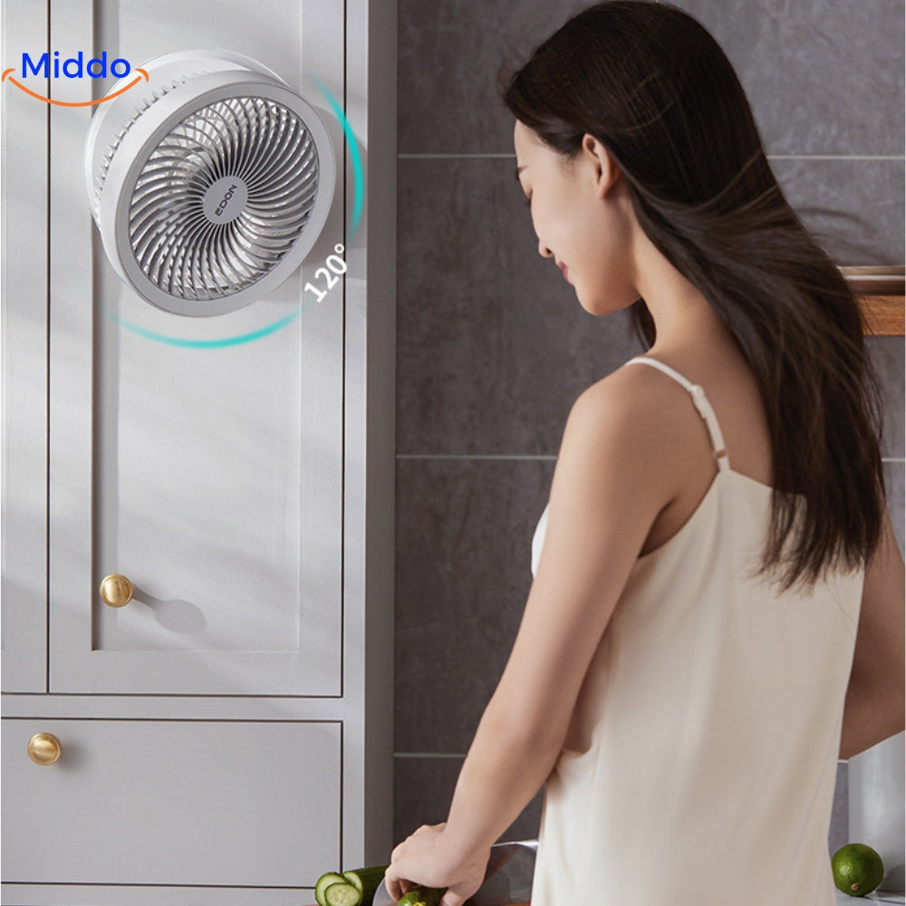femme profitant de la fraîcheur du ventilateur dans la cuisine, cheveux au vent