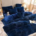 Foto van 5 set donker blauw fluffy fleece beddengoed met gratis hartjes kussen netje opgemaakt op bed met kleine grijze knuffelbeer.