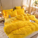 Geel 5 set fluffy fleece beddengoed met hartjes kussen netjes opgemaakt met klein berenknuffeltje op bed.