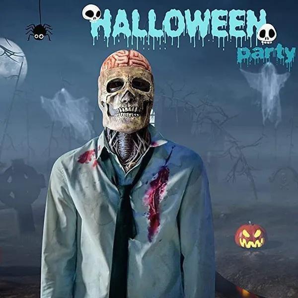 Masque tête de mort d’Halloween avec cerveau apparent, porté avec un costume de zombie ensanglanté sur un décor effrayant d’Halloween