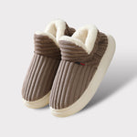 Bruine fleece pantoffels met witte fleece voering en witte rubberen zool.