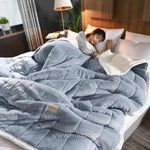CozyFleece lichtblauw pluche woldeken op bed met slapende persoon
