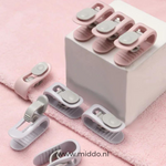 Verschillende kleuren dekbedklemmen op roze handdoek