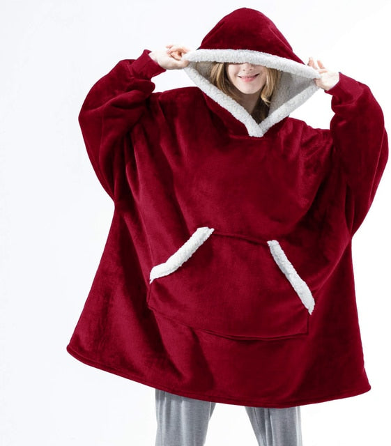 Persoon draagt een rode Sherpa Fleece XXL hoodie met witte rand.