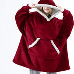 Persoon draagt een rode Sherpa Fleece XXL hoodie met witte rand.