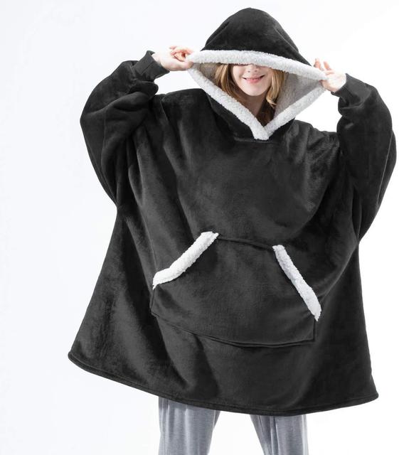 Persoon draagt een zwarte Sherpa Fleece XXL hoodie met witte rand.