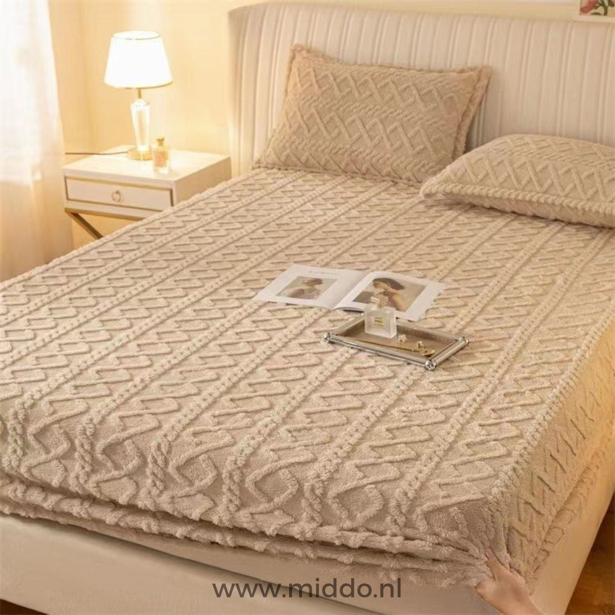 Drap-housse en polaire beige à motif torsadé bien tendu sur un lit avec taies assorties