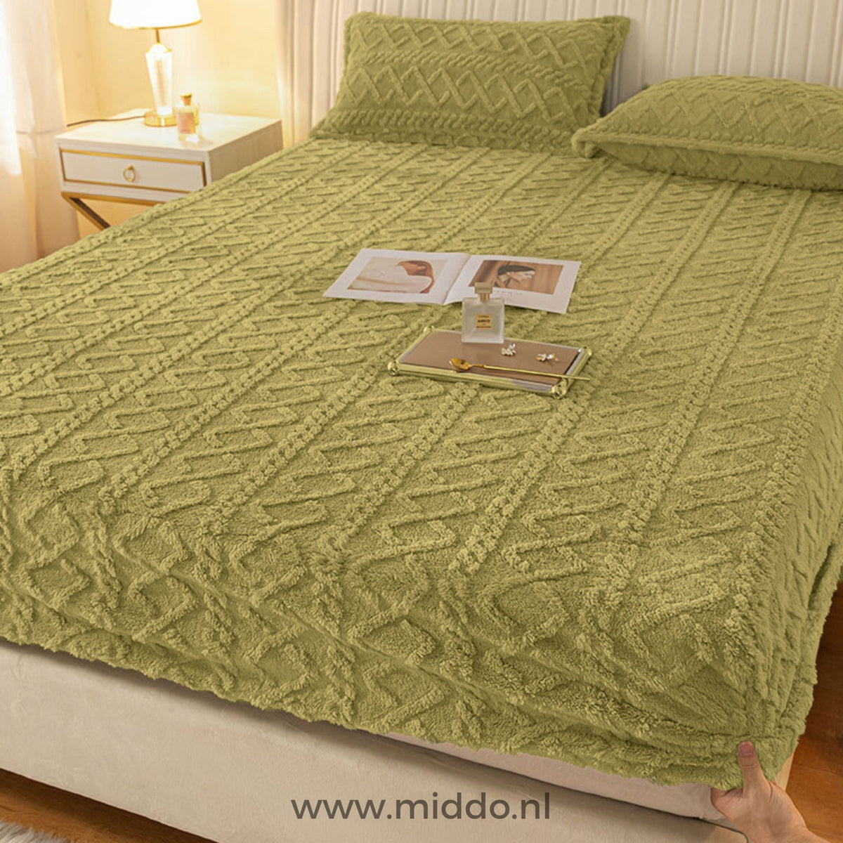 Drap-housse en polaire vert gazon à motif torsadé bien tendu sur un lit avec taies assorties