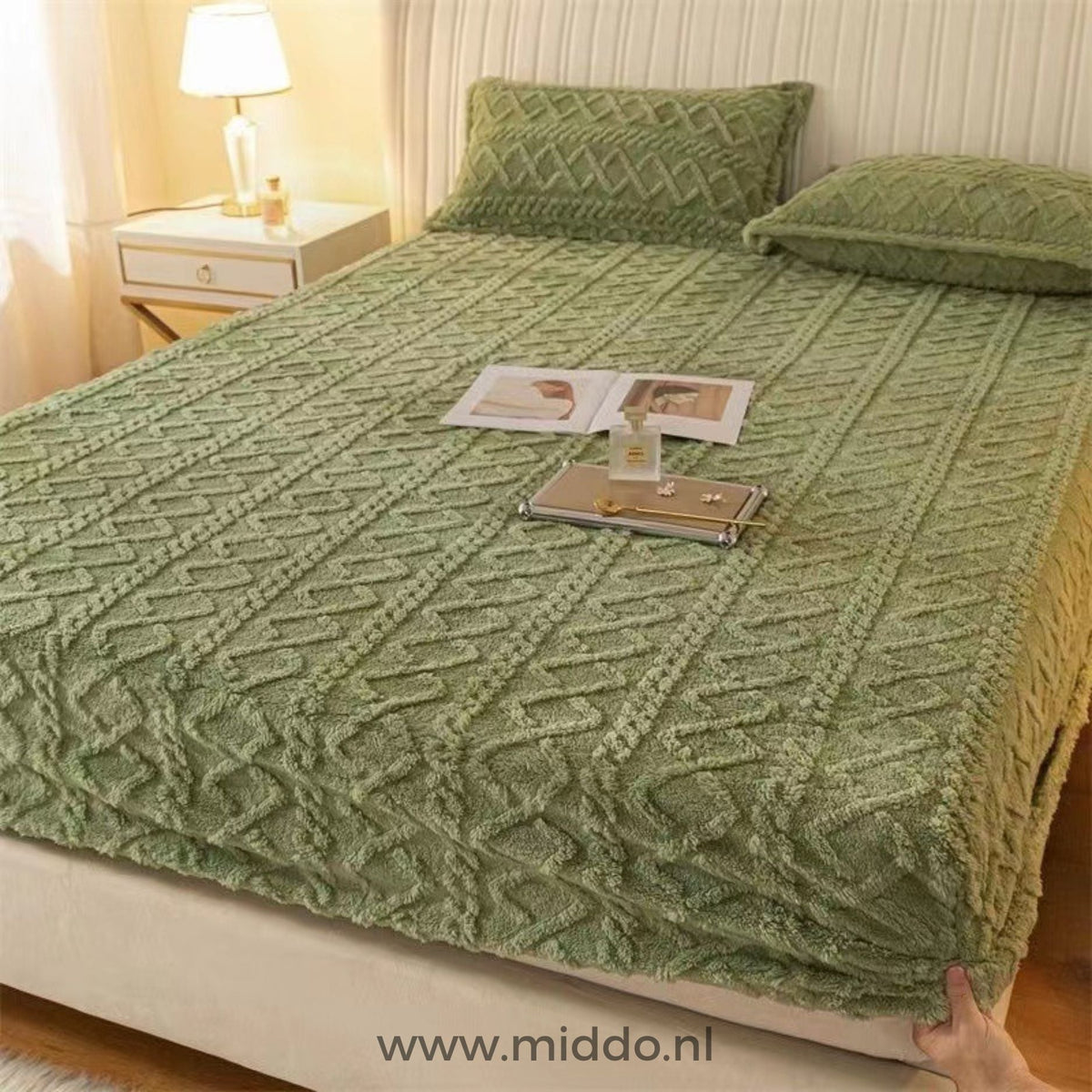Drap-housse en polaire vert mousse à motif torsadé bien tendu sur un lit avec taies assorties