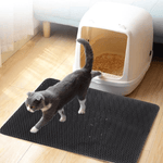 Kat loopt op antislip kattenbakmat voor kattenbakvulling.Kat op kattenbakmat voor kattenbak in huis.