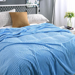 Lichtblauwe fluwelen fleece deken op een opgemaakt bed