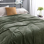 Groene fluwelen fleece deken op een opgemaakt bed