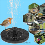 Detail van een zwarte fontein met zon pictogram en roodborstje