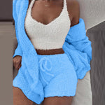 Vrouw in blauwe SheCutie comfy set met short, top en vest zittend op bank
