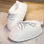 Witte bewerkte sloffen met grijze veters en een antislipzool.