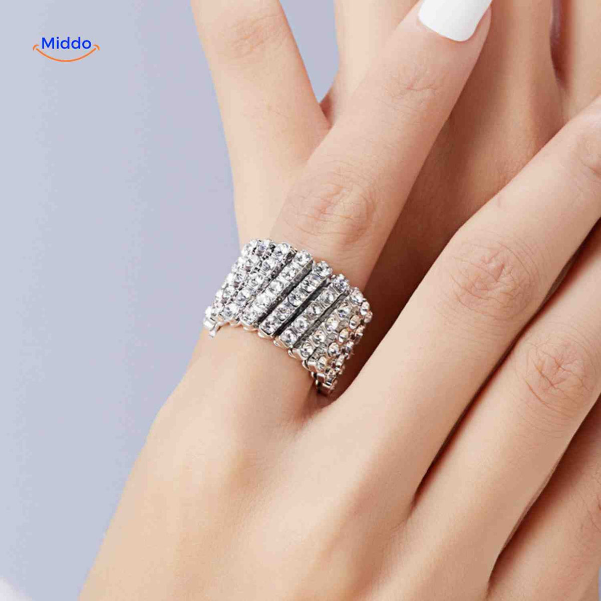 bague réglable dorée large ornée de strass blancs, portée comme bijou élégant