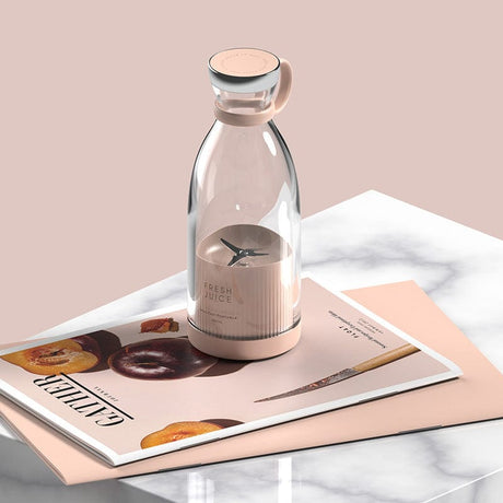 blender sans fil pour smoothies posé sur une table à côté d'un magazine