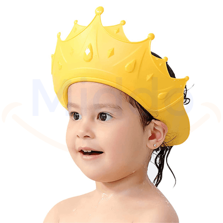 enfant portant un bonnet de douche en forme de couronne jaune pour se protéger les yeux