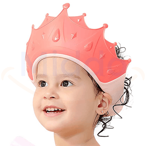 enfant portant un bonnet de douche en forme de couronne rose pendant le bain