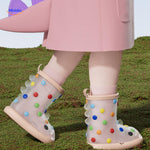 enfant en imperméable rose avec bottes de pluie requin 3d à pois colorés