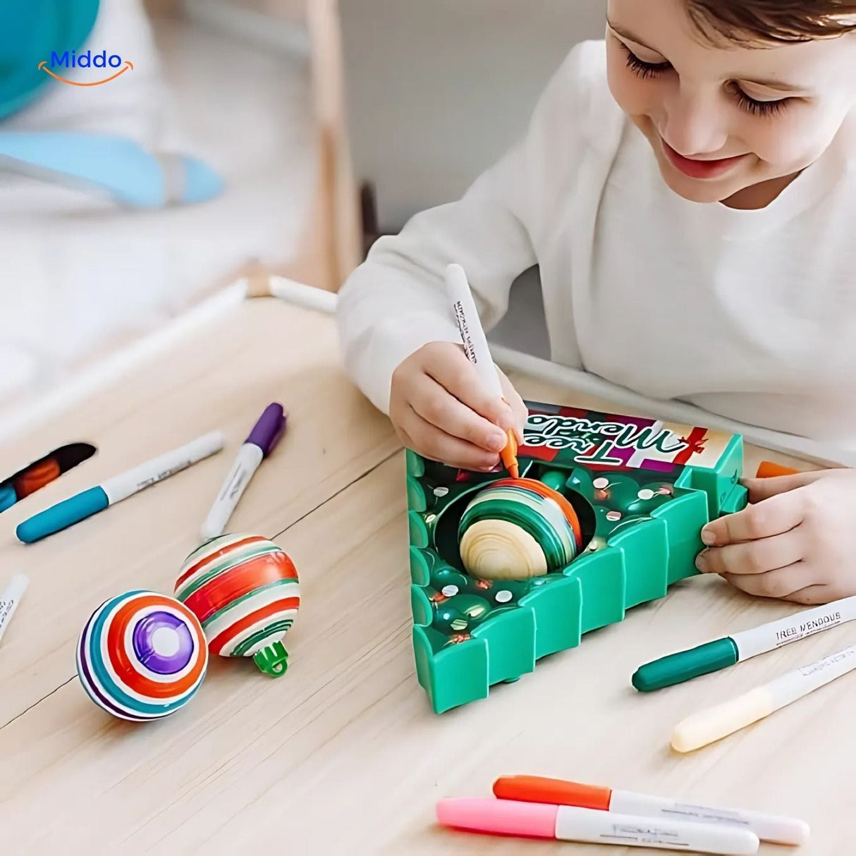 kit diy boules de noël : enfant qui décore une boule personnalisée à la peinture électrique