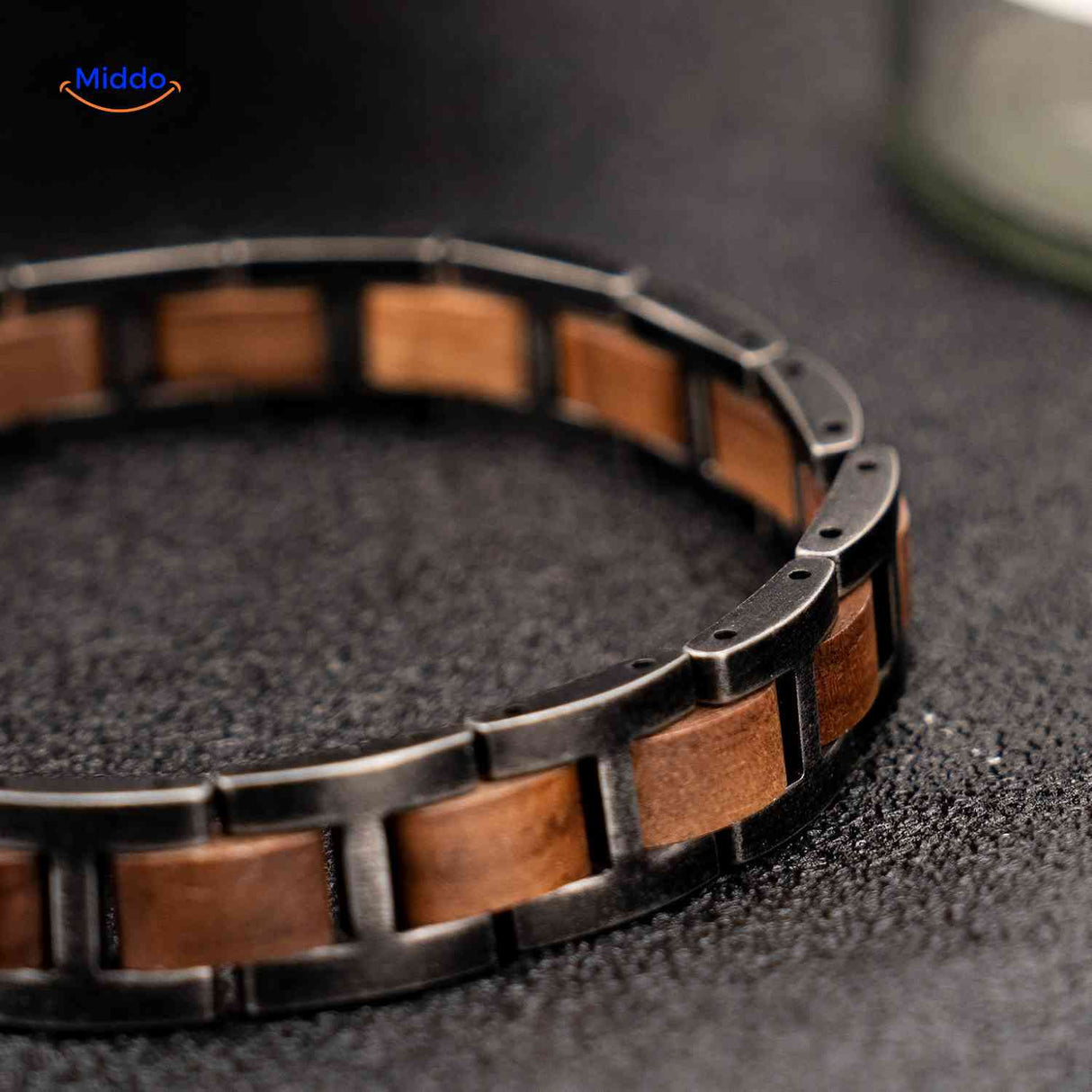 bracelet bois et métal posé à plat, gros plan sur la texture et les maillons
