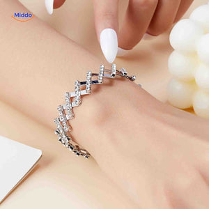 bracelet doré large orné de strass blancs porté au poignet, bague réglable transformée