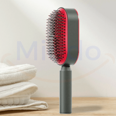 brosse à cheveux avec bouton nettoyant rouge posée sur son support