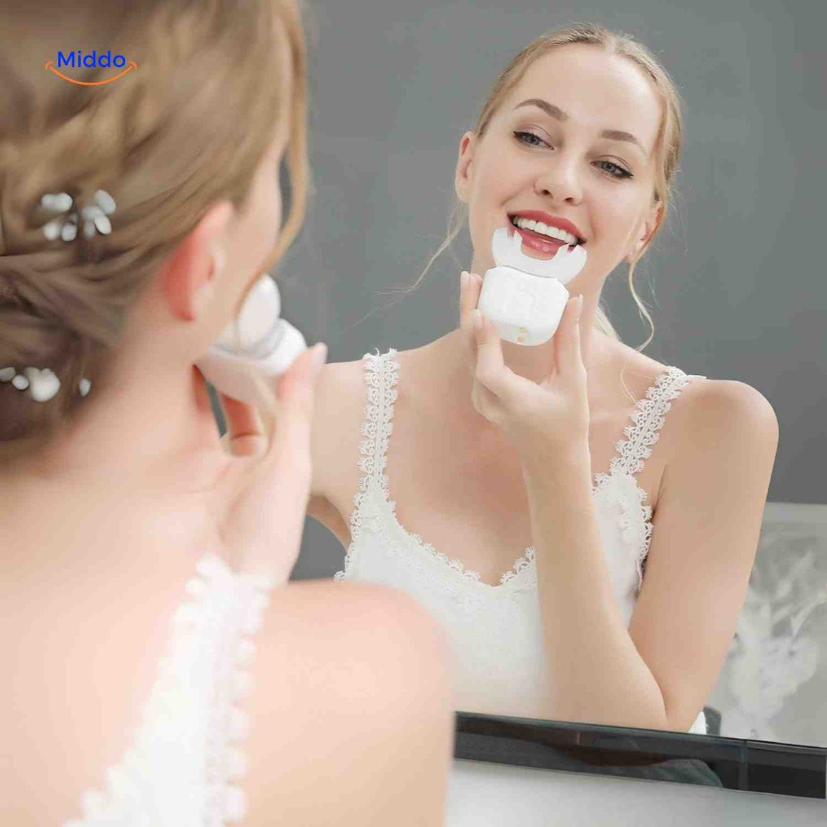 brosse à dents électrique en forme de U utilisée devant un miroir pour un brossage automatique complet