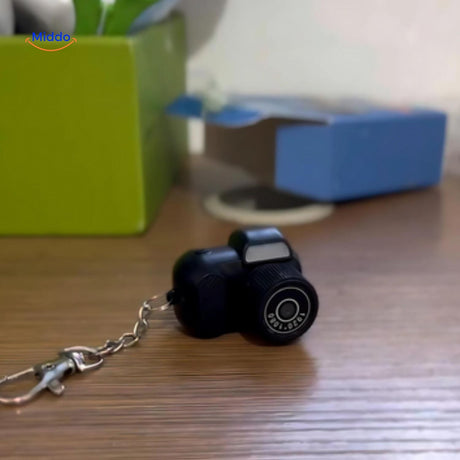 camera hd compacte en équilibre à côté d'un écouteur pour montrer ses dimensions miniatures