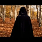 cape velours noire à capuche en forêt, atmosphère halloween mystérieuse